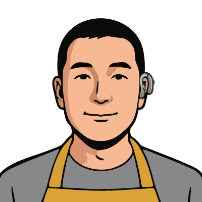 A Korean man about 34 with light warm skin, short black hair, a clearly visible silver-gray behind-the-ear hearing aid hooked over his right ear, a mustard-yellow apron over a gray t-shirt. Pop comic style.
